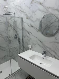 a white bathroom with a sink and a mirror at Luxury Rooms K91 in Foggia +12 photos