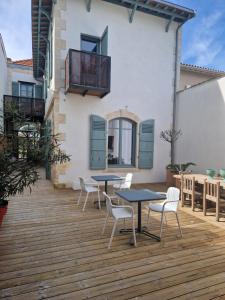 a patio with tables and chairs on a wooden deck at Welcôm Apparts-chic et intimiste-100m du Port in La Teste-de-Buch