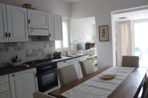 a kitchen with a wooden table and white cabinets at Il silenzio delle colline Umbre - Vicino Todi in Todi