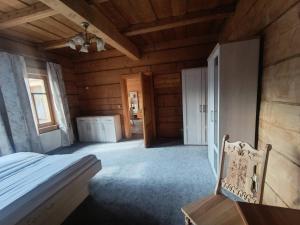 a bedroom with a bed and a wooden wall at Schronisko Stary Młyn in Zakopane