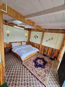 a bedroom with a large bed and a rug at The Ridge Cottages - Sainj Valley in Sainj +17 photos