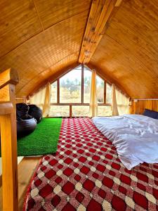 a bedroom with a bed and a red and white carpet at The Ridge Cottages - Sainj Valley in Sainj