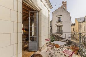 a balcony with chairs and a table on a building at Maison Joséphine avec garage privé in Blois