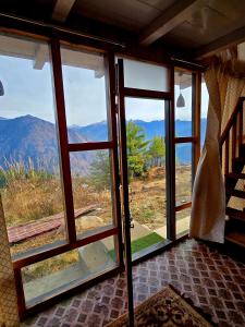 a room with a window with a view of a mountain at The Ridge Cottages - Sainj Valley in Sainj