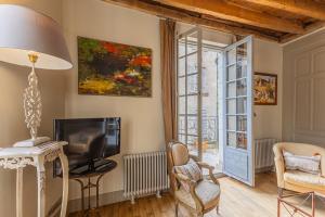 a living room with a tv and a window at Maison Joséphine avec garage privé in Blois