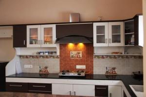 a kitchen with white cabinets and a stove top oven at Comfort Nest in Coimbatore