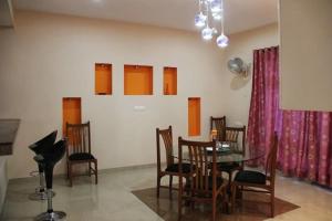 a dining room with a table and chairs at Comfort Nest in Coimbatore +17 photos