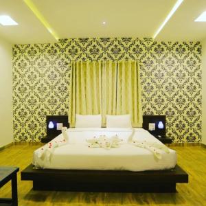 a bedroom with a large bed with flowers on it at Veda Resort in Udaipur +3 photos