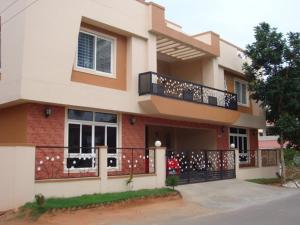 a large house with a balcony on a street at Comfort Nest in Coimbatore