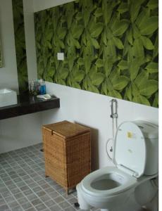 a bathroom with a toilet with a green wall at Comfort Nest in Coimbatore