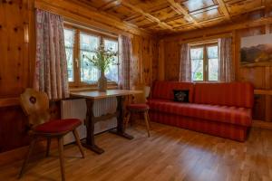 a living room with a red couch and a table at Landhaus Barbara in Silbertal +35 photos