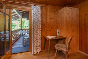 a wooden room with a desk and a balcony at Landhaus Barbara in Silbertal
