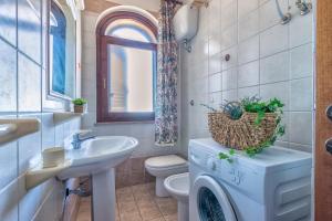 a bathroom with a sink and a washing machine at Dimore Dell'Isola Rossa in Isola Rossa +80 photos