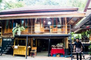 a woman standing in front of a building at Baan Kao Kod in Nakhon Si Thammarat