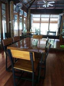 a dining room with a wooden table and chairs at Baan Kao Kod in Nakhon Si Thammarat