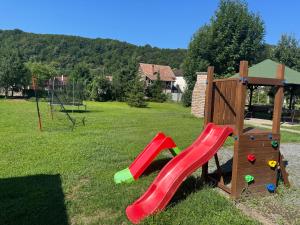 a playground with a red slide in a park at Casa Flamingo in Sovata