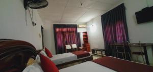 a hotel room with two beds and a window at Dee Ella hotel in Danowita