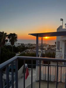 a view of the sunset from the balcony of a house at Two BR Sea View with Balcony and Pool Paphos in Khlorakas