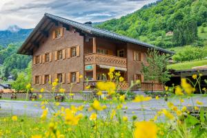 a large wooden house in a field of flowers at Landhaus Barbara in Silbertal