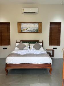 a bedroom with a large bed with white sheets at Nilah Private Pool Villa in Kappil +4 photos
