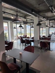 a dining room with tables and chairs and windows at Leon Hotel in Kashari