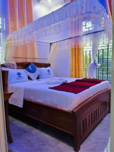 a bedroom with a large bed with a canopy at Triple E Lodge Kibaha in Kibaha