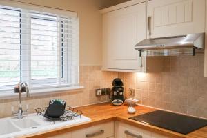 a kitchen with a sink and a counter top at Roxby a stunning bungalow on the banks of the river within a 2 minute walk of Lake Ullswater and Pooley Bridge in Pooley Bridge
