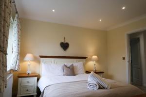 a bedroom with a bed with a heart on the wall at Roxby a stunning bungalow on the banks of the river within a 2 minute walk of Lake Ullswater and Pooley Bridge in Pooley Bridge