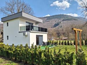 a white house in a field with trees at Oaza mira 2 in Jajce