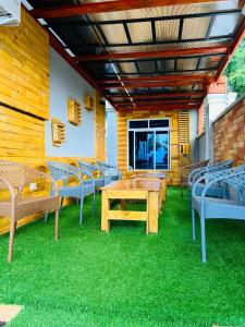 a patio with chairs and a table on the grass at Triple E Lodge Kibaha in Kibaha