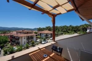 a view from the balcony of a house with a wooden table at Ankakyaka Apart Hotel in Muğla
