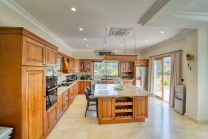 a kitchen with wooden cabinets and a table with chairs at Sunset Poseidon by Carrington in Kyrenia