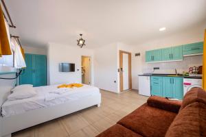 a bedroom with a bed and a kitchen with green cabinets at Ankakyaka Apart Hotel in Muğla