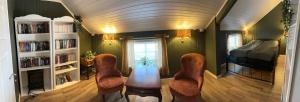 a room with a table and chairs and a bed at Låven Parsellhage in Hoset