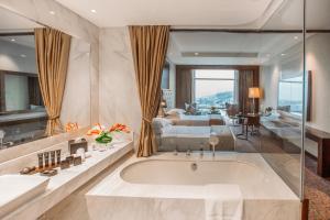 een badkamer met een bad en een slaapkamer bij The Biltmore Tbilisi Hotel in Tbilisi City