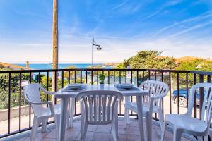 a table and chairs on a balcony with the ocean at Dimore Dell'Isola Rossa in Isola Rossa