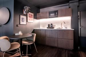 a kitchen with a table and chairs and a sink at La Suite Bleue in Cholet