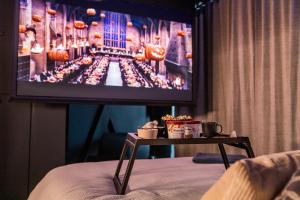 a tv on a wall in a room with a table at La Suite Bleue in Cholet
