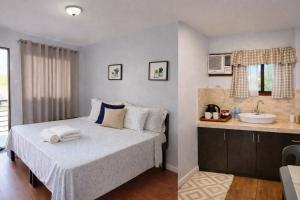 a bedroom with a bed and a sink at Point Gate Inn in Bacolod