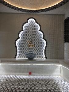 a bathroom with a bath tub with a bowl at MUXSIN s in Bukhara +55 photos