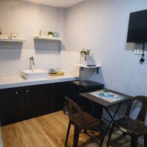 a kitchen with a sink and a table with chairs at Point Gate Inn in Bacolod