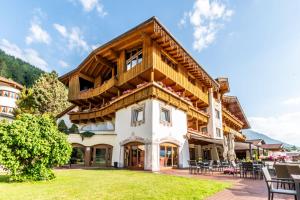 a large house with a wooden roof at Sporthotel Cristall in Fulpmes