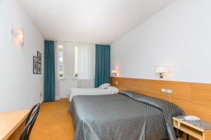 a hotel room with a bed and a desk and a desk at Albergo Al Caminetto in Nago-Torbole