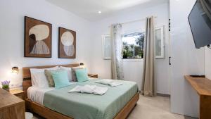 a bedroom with a bed and a window and a television at Villa Filothea with Jacuzzi & SV by CorfuEscapes in Spartýlas