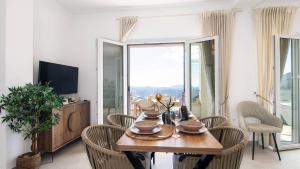 a dining room with a table and chairs and a television at Villa Filothea with Jacuzzi & SV by CorfuEscapes in Spartýlas