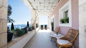 a balcony with chairs and a view of the water at Villa Filothea with Jacuzzi & SV by CorfuEscapes in Spartýlas
