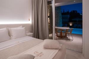 a bedroom with a bed and a table and a balcony at Apartment Athina with direct pool access - GH8 in Gialova +34 photos