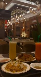 a table with plates of food and drinks in a restaurant at Gulf Star Hotel Hargeisa in Hargeysa