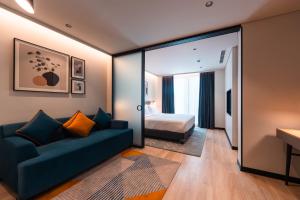 a hotel room with a couch and a bed at Alt Life Stays - Manyata Tech Park in Bangalore