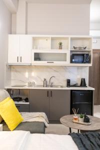 a kitchen with white cabinets and a table at Breeze Apartments Megara - Linea in Megara